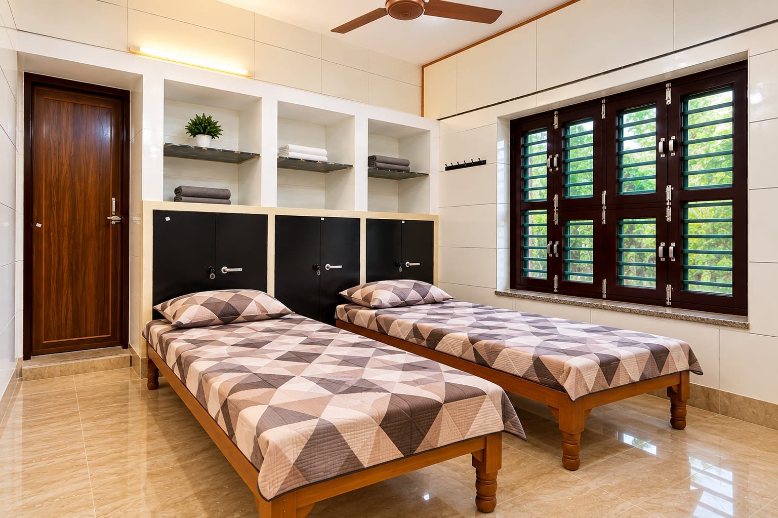 A double-sharing room with two single beds, lockers below the open shelves, a ceiling fan and a wide window looking onto trees